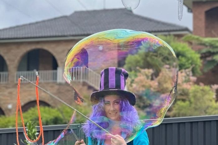 Mad Hatter character entertainer creating giant bubbles at a children's party in Sydney.